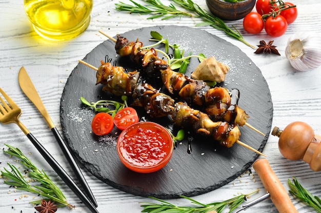 Rapana skewers with vegetables on a black stone plate Restaurant food Seafood Rustic style Flat Lay