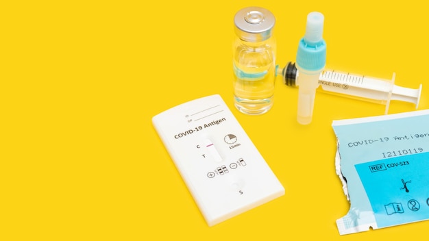 Rapid antigen test kit for viral disease covid19 with positive result top view on yellow background with copy space