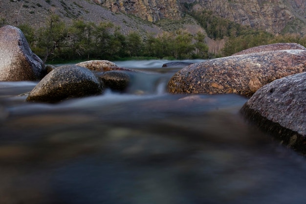 the rapid running of mountain rivers on a quiet summer evening on a long shutter speed