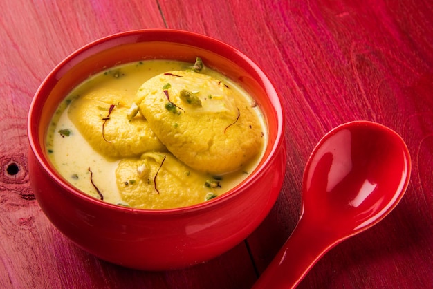 Ras malai or rossomalai is a dessert from Bengal, India. It's a a rich cheesecake without a crust, with Saffron or Kesar &amp; Pistachio toppings. Served in a bowl over wooden or colourful background