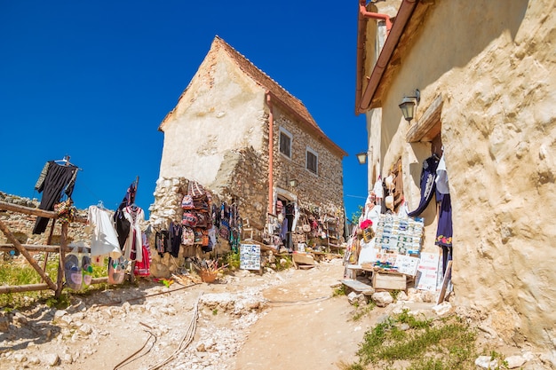 Rasnov, Roemenië - augustus 2019: Binnenplaats, oude huizen en souvenirwinkels van de Rasnov Citadel - een middeleeuws fort in traditionele Roemeense stijl in de buurt van de stad Brasov. Transsylvanië. Zomer.