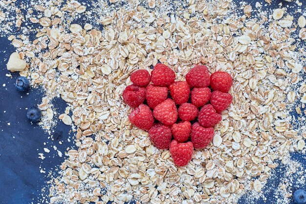 Raspberries and blueberries on blue. cereals