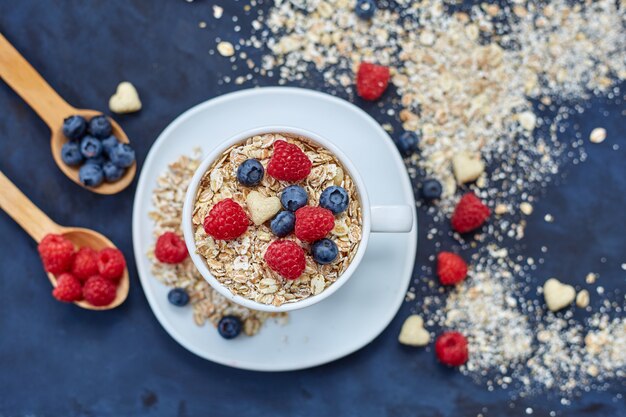 Raspberries and blueberries on blue. Cereals.