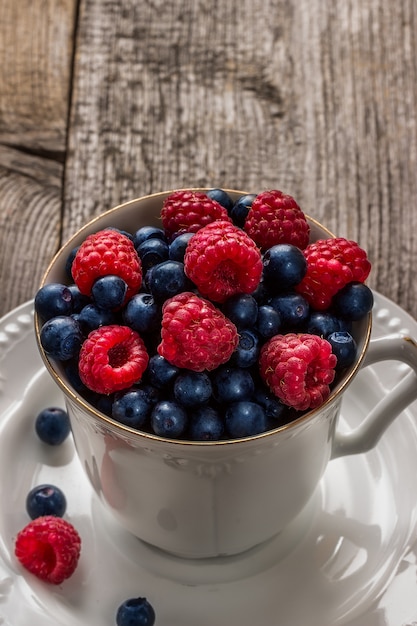 Raspberries and blueberries in ceramic bowl