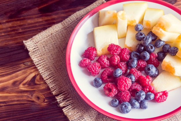 Raspberries, blueberries and slices of melon 