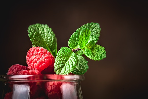 Photo raspberries in a cup on a dark background