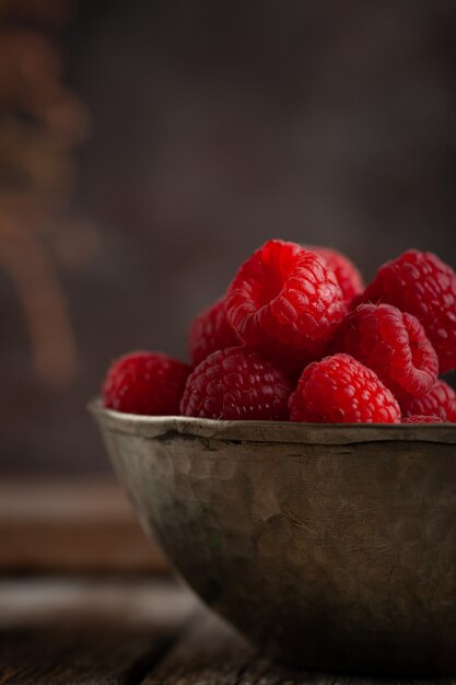 Raspberries on natural wooden table.