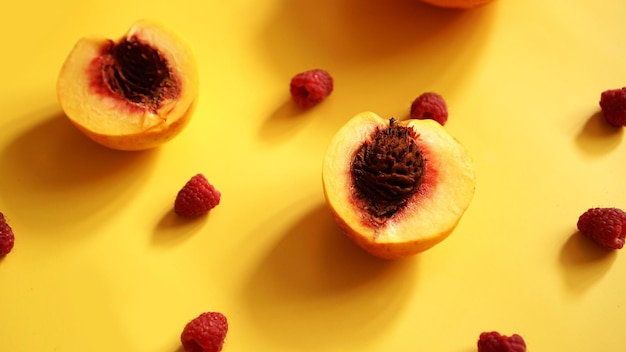 Raspberries and peaches for healthy summer eating - on yellow background