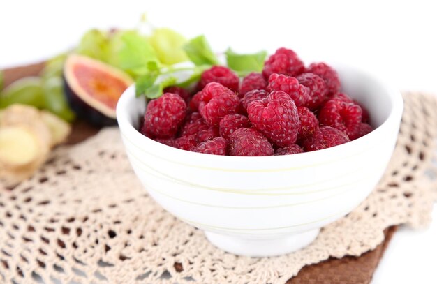 Raspberries in small bowl on napkin isolated on white