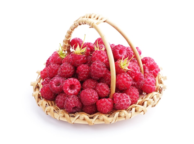 Raspberries in a small wicker basket on a white background