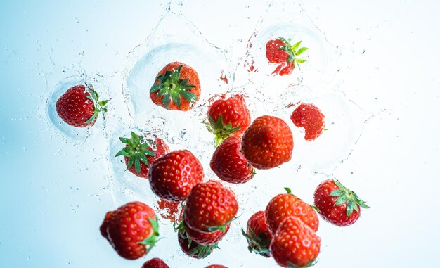 Raspberries splashing into clear water view from top