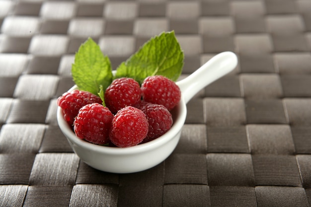 Raspberries with basil leaves