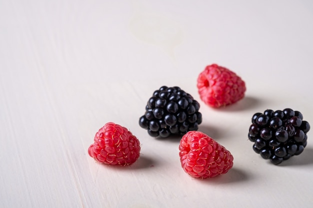 Raspberry and blackberry sweet organic juicy berries on white, macro