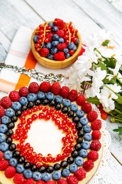 Raspberry and blueberry cheesecake on wooden table