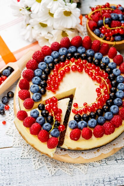 Raspberry and blueberry cheesecake on wooden table