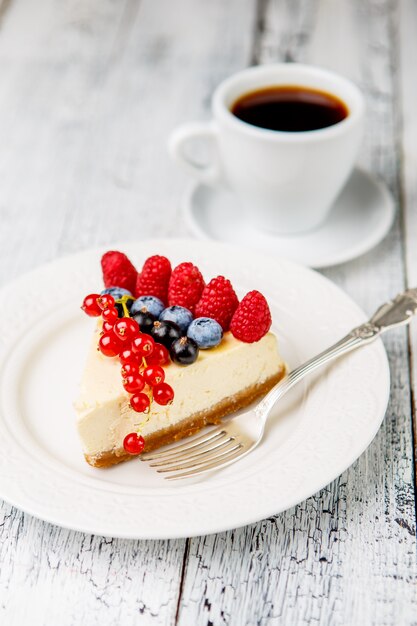 Raspberry and blueberry cheesecake on wooden table