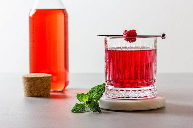 Photo raspberry cocktail in a glass on a marble stand