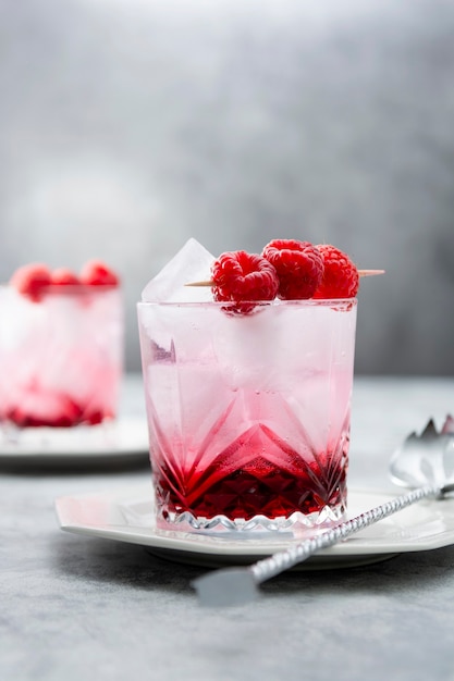 Raspberry cold drink cocktail with mint leaf and ice cubes. Summer fresh beverage in glasses