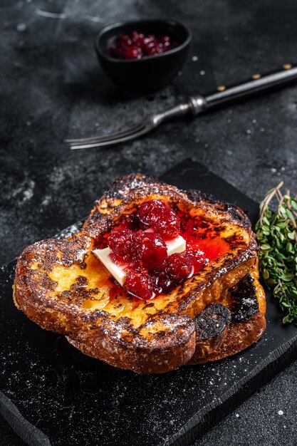 Raspberry french toast with butter on marble board black
background top view