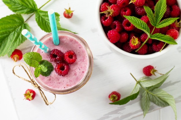 Frullato di yogurt alla frutta al lampone o frullato di latte in un barattolo di vetro copia spazio