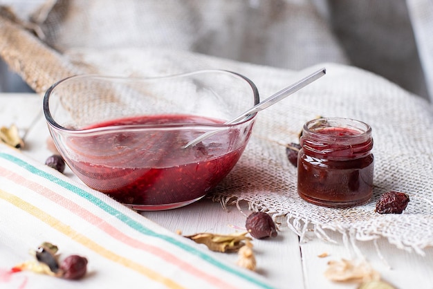 Marmellata di lamponi sul tavolo un vasetto di marmellata rossa su un tessuto chiaro