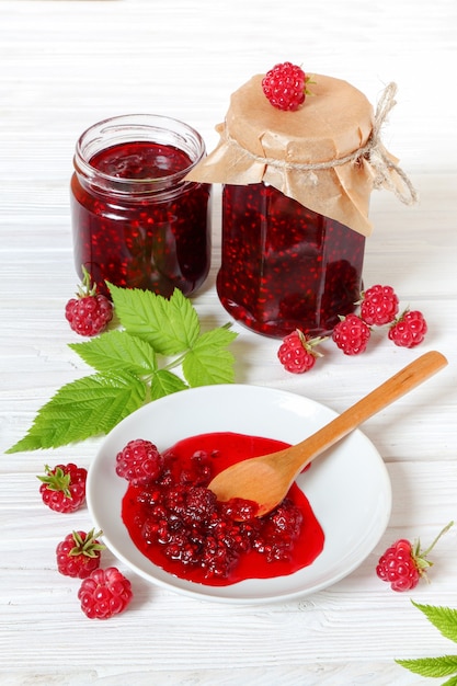 Foto marmellata di lamponi su un tavolo di legno bianco