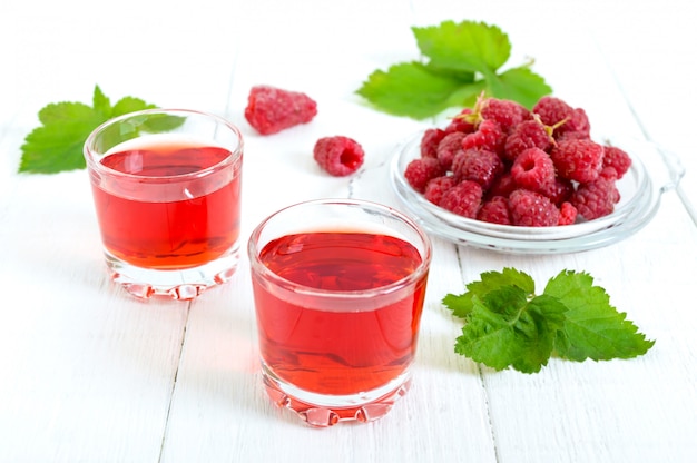 Raspberry juice in glasses and fresh berries