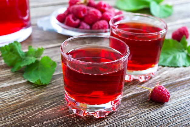 Raspberry juice in glasses and fresh berries