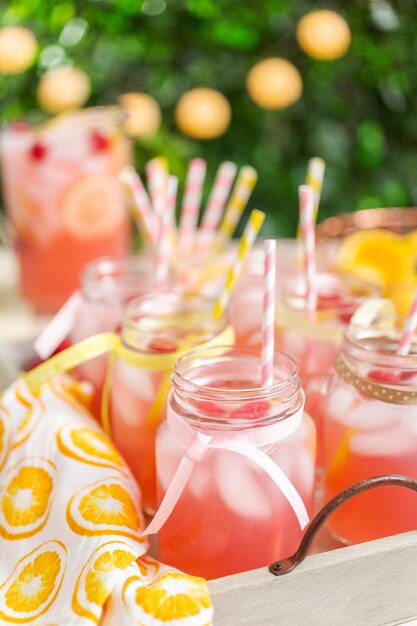 Photo raspberry lemonade garnished with fresh lemon and raspberries in drinking mason jars.