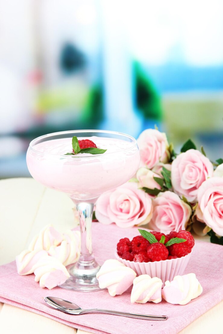 Photo raspberry milk dessert in cocktail glass on bright background