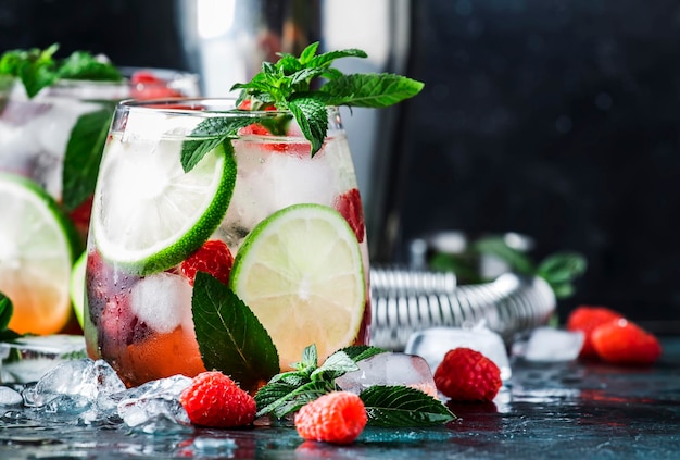 Raspberry Mojito Lemonade with lime and fresh mint in glass on gray background Summer refreshing cocktail