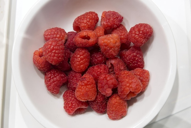 Photo raspberry on plate isolated on white background