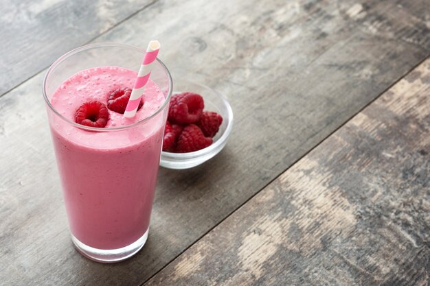 Photo raspberry smoothie in glass on wooden table