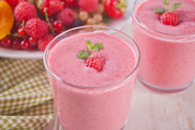 Raspberry smothies and raspberry fruit on the concrete background