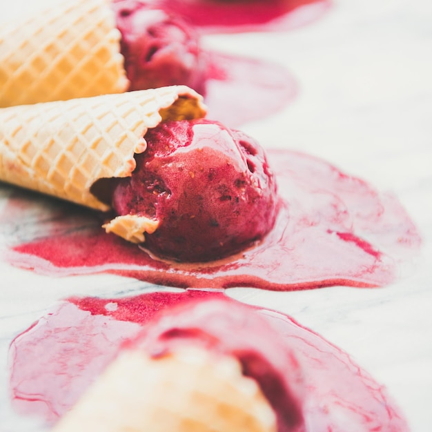 Raspberry sorbet icecream scoops in cones selective focus square crop