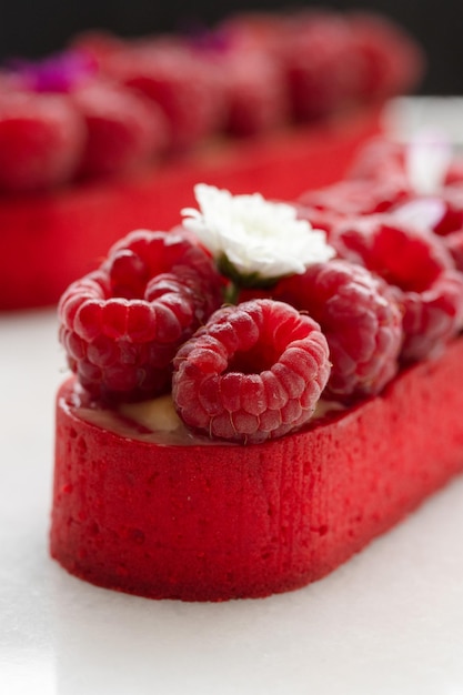 Foto raspberry tartlet versierd met bloemen witte achtergrond closeup