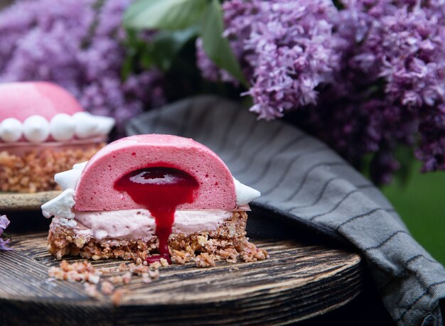 Raspberry tartlets  in section on the little wooden table and a violet lilac