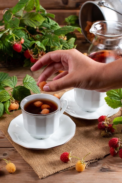 Tè al lampone con bacche naturali su tavola di legno tè vitaminico per la perdita di peso