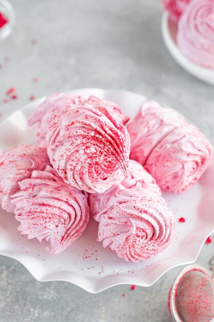 Raspberry zephyr Russian marshmallows on a cake stand on a grey concrete background Copy space