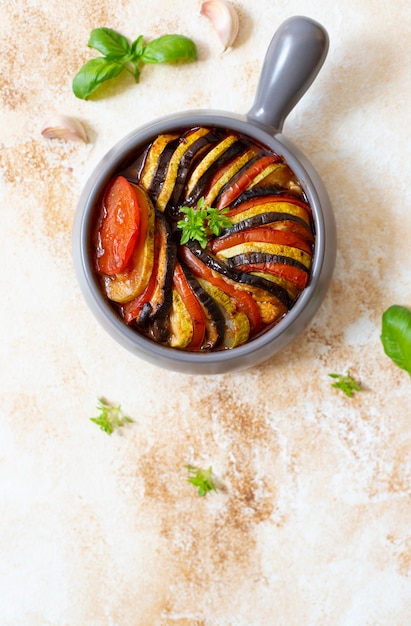 焼きたての夏野菜のラタトゥイユの伝統的なフランス料理。ベジタリアンとダイエット食品。フランス料理/食べ物。大理石の明るい背景、上面図、コピースペース