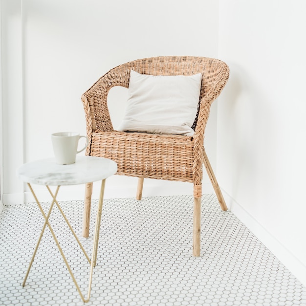 Rattan chair with pillow and marble coffee table at balcony with mosaic floor