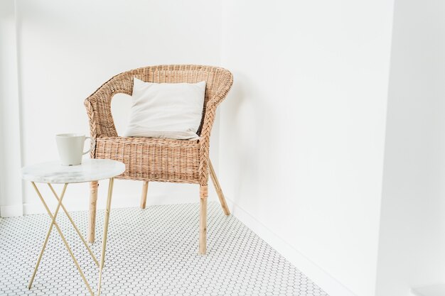 Rattan chair with pillow and marble coffee table at loggia with mosaic floor