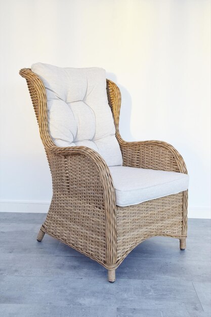 Rattan chair with seating cushions for relaxing on the terrace. Home decor.