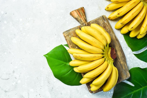 Rauw biologisch boeket bananen klaar om te eten op een stenen achtergrond Gratis kopieerruimte Bovenaanzicht