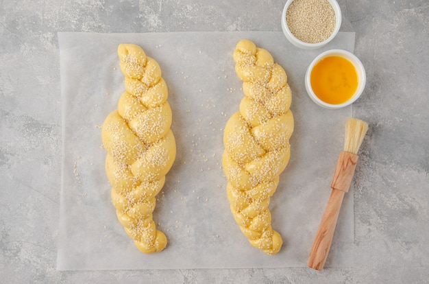 Rauw brood van challah Joods brood op een lichtgrijze achtergrond. Bovenaanzicht, kopieer ruimte.