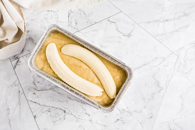 Rauw deeg voor bananenbrood in een ovenschaal op tafel social media trendy bovenaanzicht