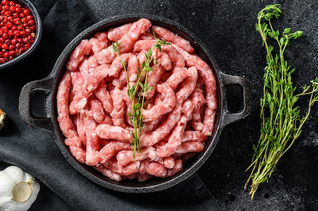 Rauw gemalen varkensvlees. Biologisch gehakt, gehakt. Zwarte achtergrond. Bovenaanzicht.