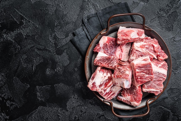 Rauw in blokjes gesneden rundvlees en lam gemarmerd vlees in stalen keukenblad Zwarte achtergrond Bovenaanzicht Kopieer ruimte