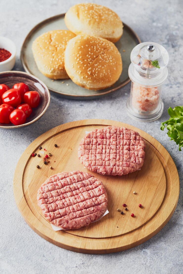 Rauw kalfsgehakt hamburger steak schnitzels op houten snijplank