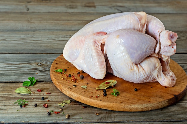 Rauw kippenkarkas klaar om te koken op een snijplank op houten achtergrond